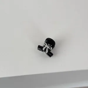 Close-up of a cute mini black hair claw clip featuring a shiny silver bow detail for bangs.