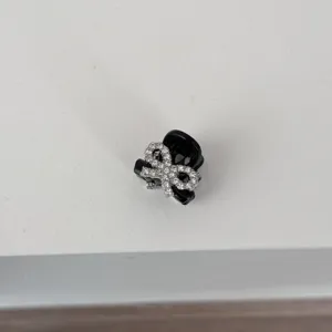 Detailed view of black rhinestone bow mini hair claw clip, perfect for side bangs.