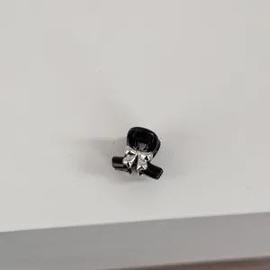 Mini black hair claw clip with silver bow detail, close-up view of cute bangs hair accessory.