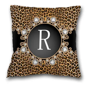 Vue détaillée de la housse de coussin léopard avec élégant cercle en diamant et lettre R.