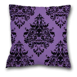 Detalle en primer plano del cojín cuadrado gótico morado con patrón de calavera negra.