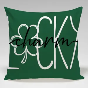 Close-up detail of green throw pillow cover with lucky charm text and shamrock print.