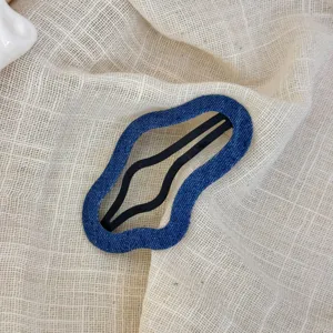 Blauwe denim golvende haarspeld detail, stijlvol onregelmatig haaraccessoire voor dagelijkse look.