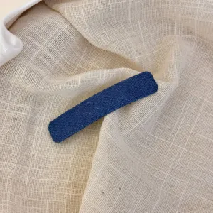 Close-up detail van een chique blauwe denim haarspeld met fijne textuurkwaliteit.