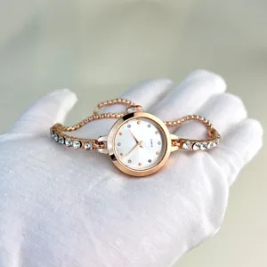 Women rose gold quartz watch with sparkling rhinestones and adjustable chain bracelet design.