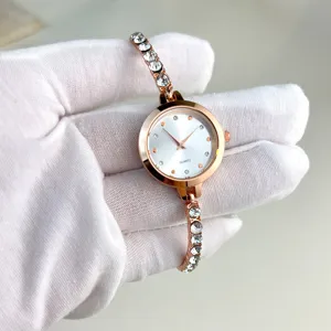 Close-up detail of women quartz watch with rhinestone bracelet, elegant rose gold design.