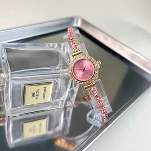 Primo piano di orologio donna al quarzo rosa con cinturino in strass su vassoio.