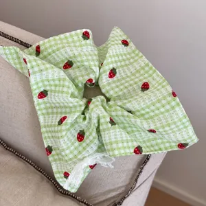 Elastico per capelli a quadretti verdi fragola pizzo, dettaglio accessorio coda di cavallo.