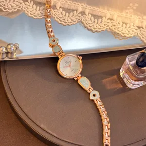 Detailansicht der Damen QuarzUhr mit unregelmäßigem grünen Armband und Sonnenstrahlzifferblatt.