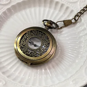 Dettaglio di orologio da tasca in bronzo vintage, orologio al quarzo floreale con catena.