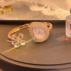 Rose gold teardrop quartz bangle watch with sparkling crystal clover motif for women.