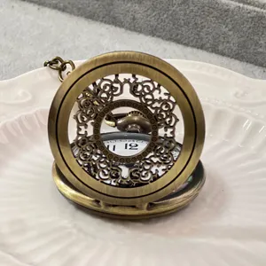 Orologio da tasca vintage in bronzo con coperchio traforato floreale e catena stile retro.