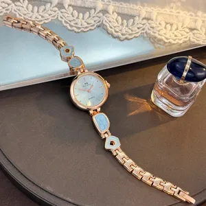 Damen Quarzuhr mit unregelmäßigem Armband, elegantes Roségold und hellblaues Zifferblatt Detail.