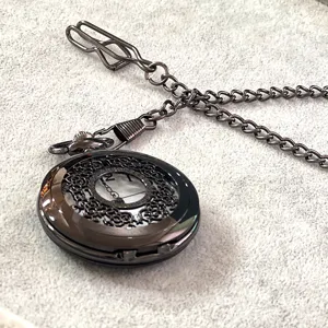 Primo piano dettagliato dell'orologio da tasca al quarzo intagliato nero vintage con catena.