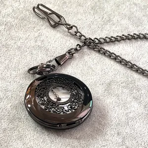 Orologio da tasca al quarzo vintage in metallo scuro con quadrante floreale traforato e lunga catena.