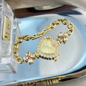 Exquisite heart-shaped rhinestone dial watch with elegant clover bracelet design.