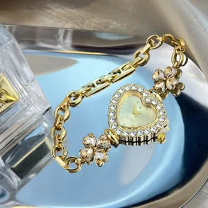 Exquisite gold rhinestone heart dial clover bracelet watch for women, stylish fashion timepiece.