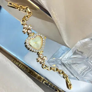 Heart-shaped rhinestone dial watch detail featuring sparkling clover crystal bracelet design.