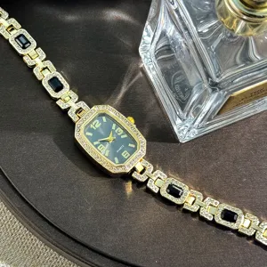 Women's gold tone rhinestone quartz watch with black dial and stylish crystal bracelet.