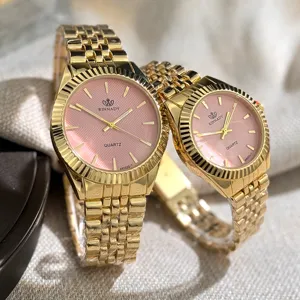 Goldenes Quarz Paar Uhren Set mit rosa strukturiertem Zifferblatt und Metallarmband.