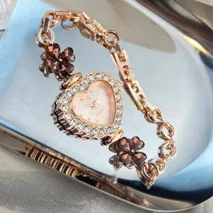 Detailed view of a rose gold heart watch featuring crystal bezel and brown clover charms.