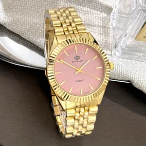 Goldfarbene Quarzuhr mit rosafarbenem Zifferblatt, geriffelter Lünette und Metallarmband.