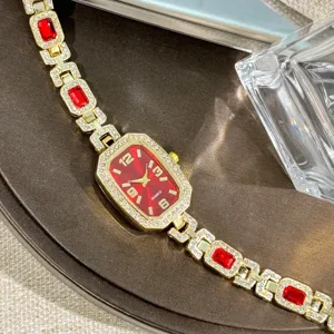Elegant luxury gold tone quartz watch with sparkling rhinestones and red gemstone links detail