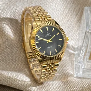 Nahaufnahme einer goldenen Quarzuhr mit schwarzem Zifferblatt und strukturiertem Armband.
