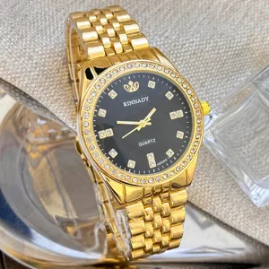 Goldene Damenuhr mit Quarzwerk, schwarzem Zifferblatt und glitzernder Strasslünette.