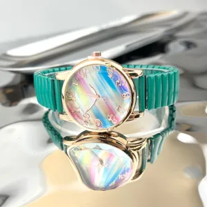 Detailansicht der Quarzuhr mit buntem Regenbogen-Zifferblatt, Goldgehäuse und grünem Stretcharmband.