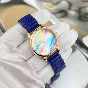 Modische Damen Quarzarmbanduhr mit buntem Regenbogen Zifferblatt und blauem elastischem Band.