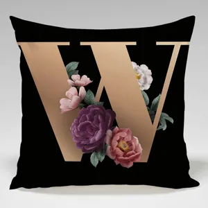 Detail view of the black cushion cover featuring a rose gold letter W and vintage floral design.