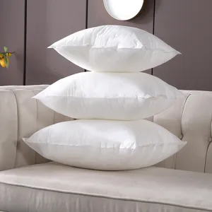White non-woven PP cotton throw pillow inserts stacked on sofa for home living room decor
