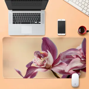 Vista dettagliata del grande tappetino da scrivania con orchidea su ufficio arancione.