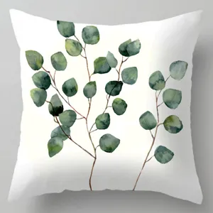 Linnen kussenhoes detail met print van groene eucalyptus bladeren in aquarel stijl.