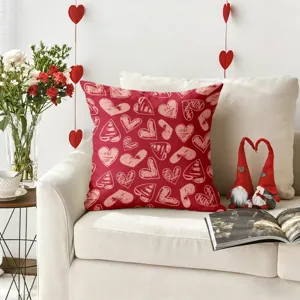 Détail du coussin rouge de Saint-Valentin avec des motifs de cœur sur un canapé.