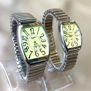 Detailopname van vierkant quartz horloge met lichtgevende wijzerplaat en metalen bandje.
