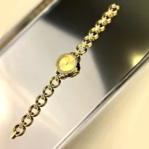 Elegante goldfarbene Quarz-Damenuhr mit Gliederarmband und funkelnder Lünette Detailansicht.