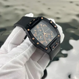 Primo piano orologio al quarzo tonneau nero, indici oro rosa e dettaglio cinturino.