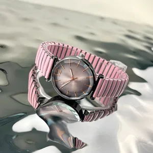 Vista de primer plano detallada de reloj de cuarzo para mujer con correa elástica rosa y esfera.