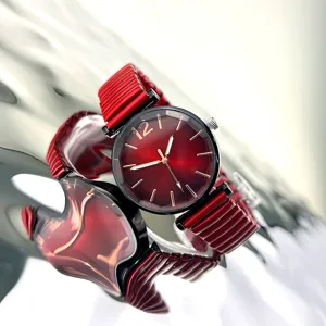 Vista detallada de reloj de cuarzo para mujer rojo con esfera soleil y correa metálica elástica.