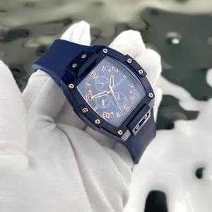 Orologio al quarzo tonneau blu trasparente con dettagli in oro rosa e cinturino in gomma.