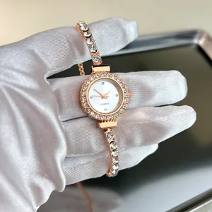 Primo piano di un orologio al quarzo in oro rosa con strass scintillanti su un cinturino sottile.