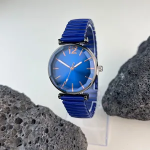 Detalle en primer plano de reloj de cuarzo para mujer con esfera azul y correa elástica.