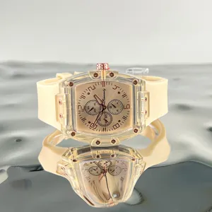 Orologio al quarzo tonneau trasparente con cinturino in gomma beige e quadrante dettagliato.
