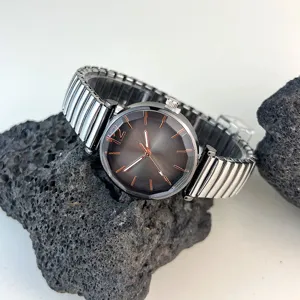 Reloj de cuarzo para mujer con correa elástica de metal, esfera oscura y marcadores de oro rosa.