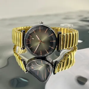 Primer plano detallado del reloj de mujer con esfera facetada y correa elástica dorada.