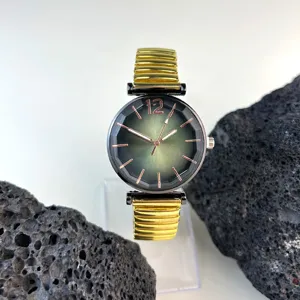 Reloj de cuarzo para mujer con esfera facetada degradada en verde y pulsera elástica dorada.