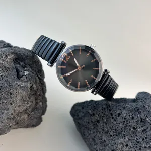 Reloj de cuarzo para mujer con esfera negra facetada y correa de metal elástica para uso diario.