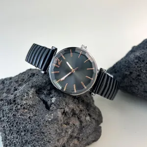 Vista detallada de reloj de cuarzo para mujer con correa elástica negra y esfera facetada.